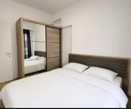 Furnished bedroom with a double bed and a large mirrored wardrobe. - image 5