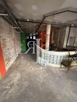 A view of an unfurnished space in its original condition with a pillar and a glass block partition wall. - image 10