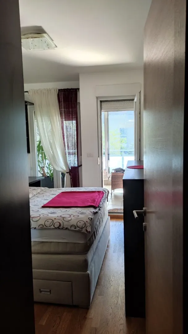 View from the hallway into the bedroom with a double bed and access to the terrace.