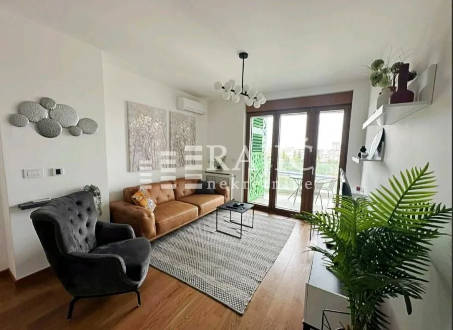 Furnished living room with a sofa and access to the terrace.