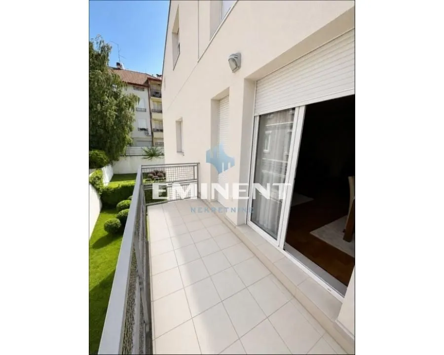 Spacious tiled terrace with railing and a view of the courtyard and surrounding buildings.