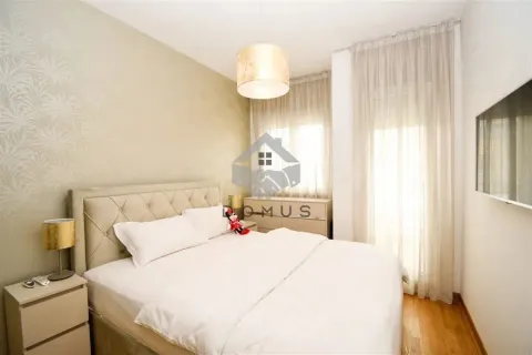 Furnished bedroom with a double bed, bedside tables, and a wall-mounted TV. - image 6