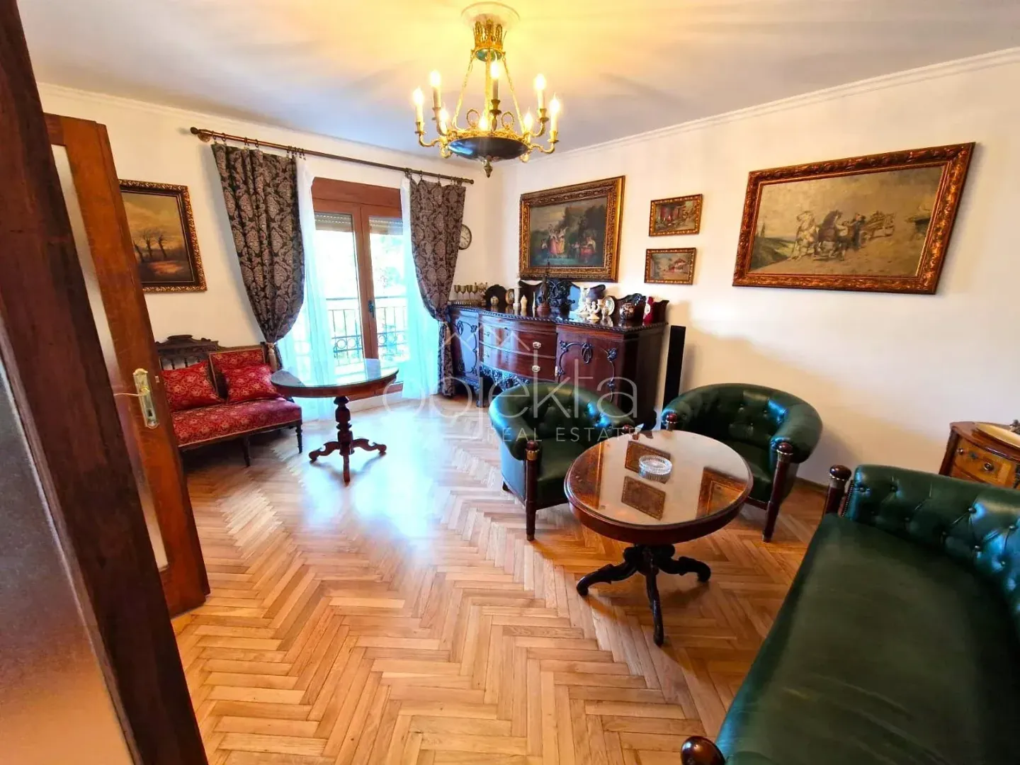 Living room with classic furniture and parquet flooring.