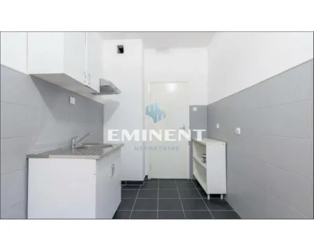 Smaller kitchen with a sink, cabinetry, and grey-and-white tiles. - image 4