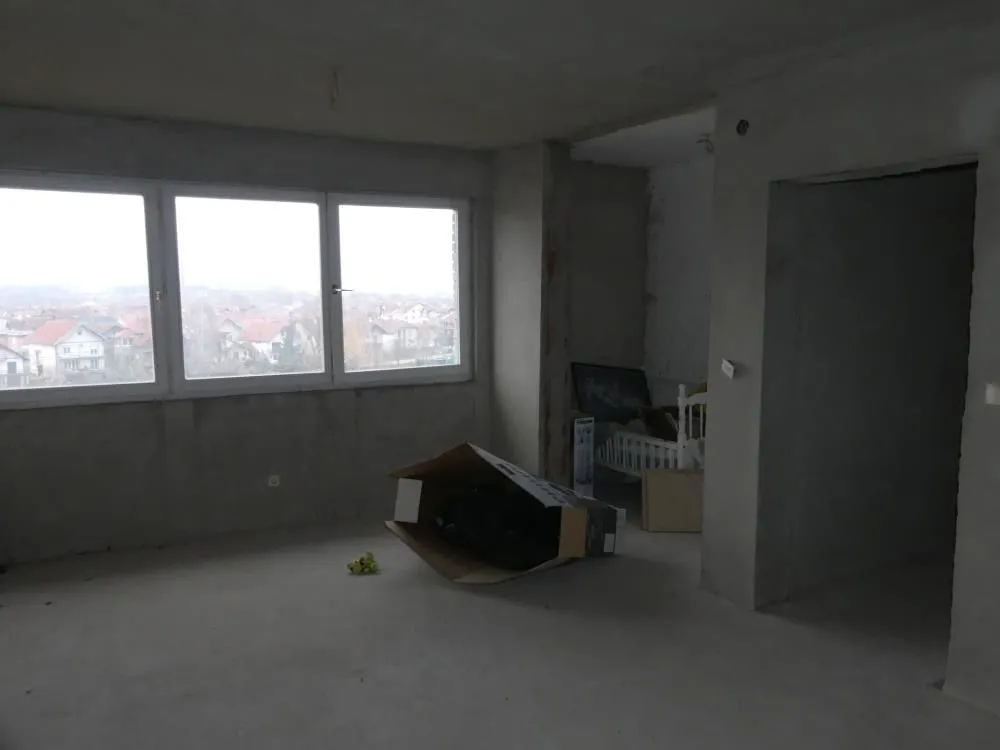 View of an unfinished room under construction with a large window.