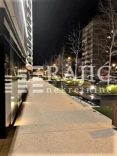 Night view of the illuminated street and sidewalk in front of the building.
