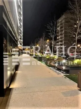 Night view of the illuminated street and sidewalk in front of the building. - image 5