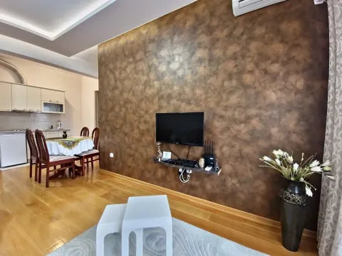 Dnevni boravak sa dekorativnim zidom, televizorom i trpezarijom u pozadini. - image 2