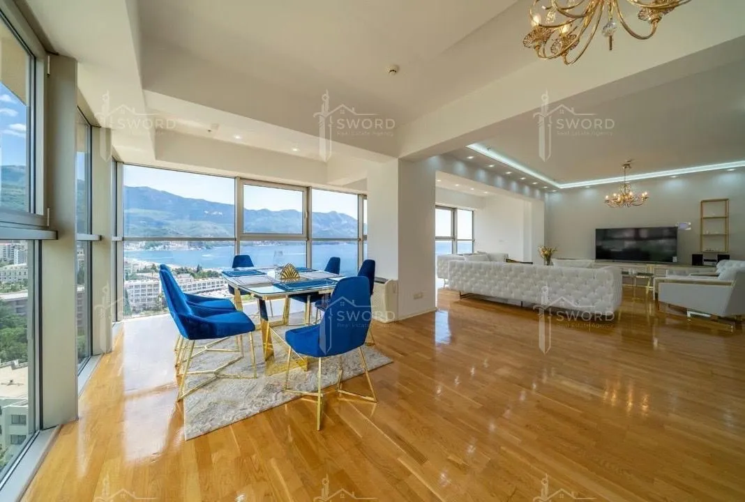 Spacious living room with dining area and large glass surfaces overlooking the sea.