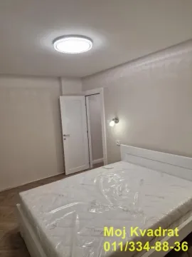 Spavaća soba sa bračnim krevetom i otvorenim vratima. - image 4