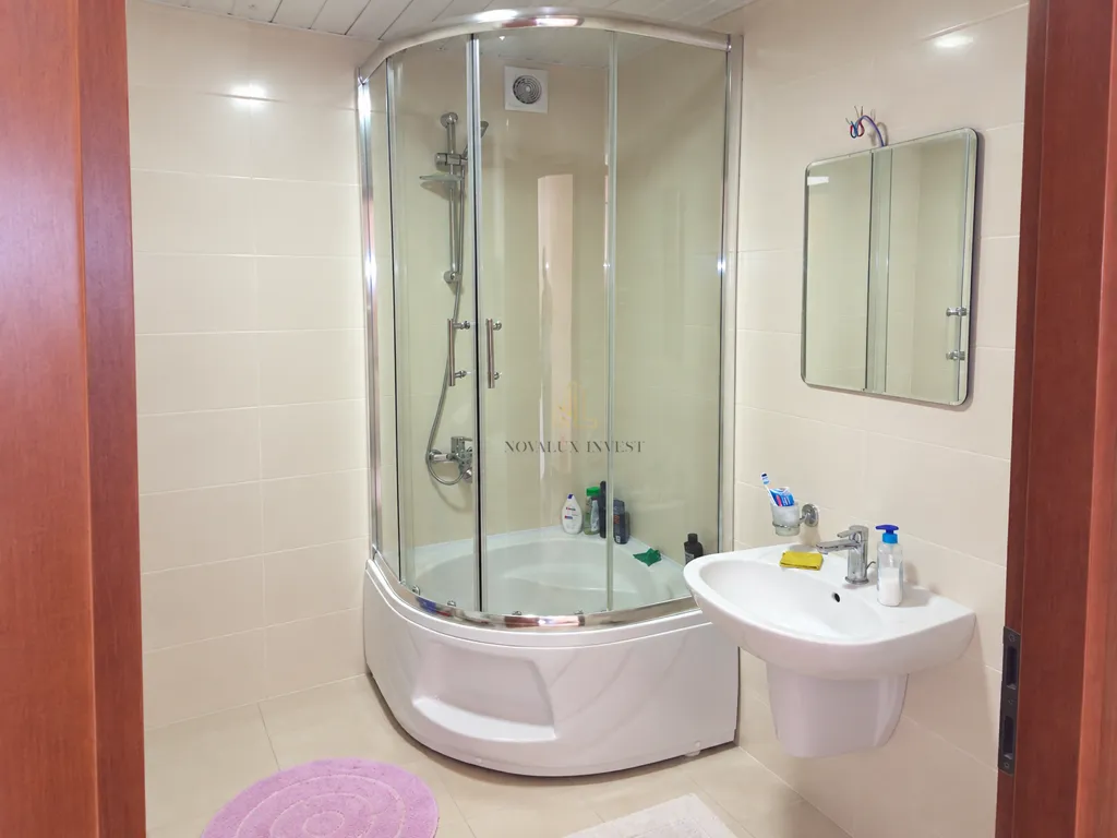 Bathroom with a shower cabin, washbasin, and mirror.