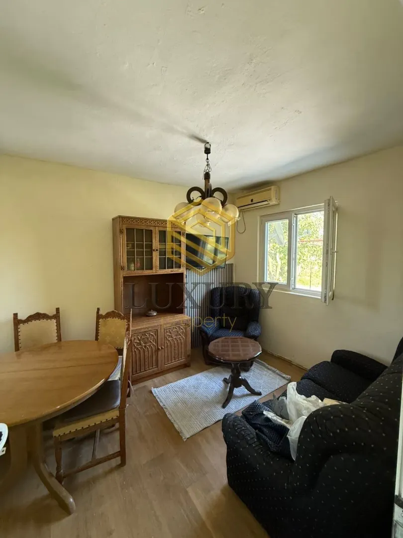 Living room with a dining table, seating furniture, and wooden cabinetry.