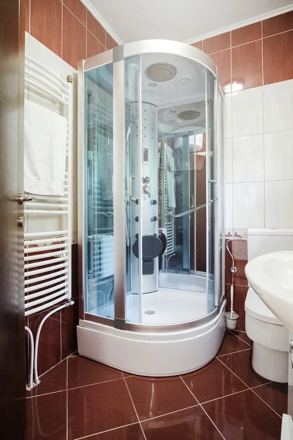 Bathroom with a shower cabin, sink, and toilet.