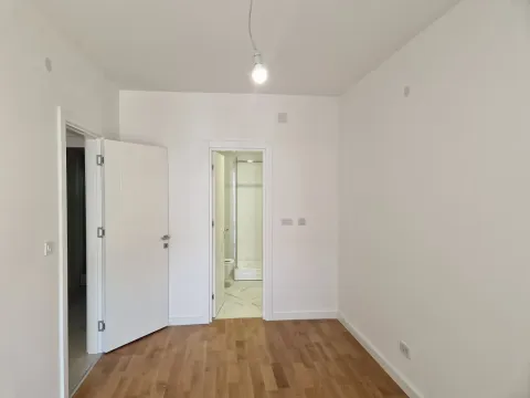 Prazna soba sa parketom i otvorenim vratima koja vode u kupatilo. - image 5