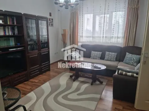 Dnevna soba sa garniturom, drvenim nameštajem i TV-om. - image 3