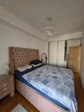 Spacious bedroom with a double bed, wardrobe, and nightstand. - image 5