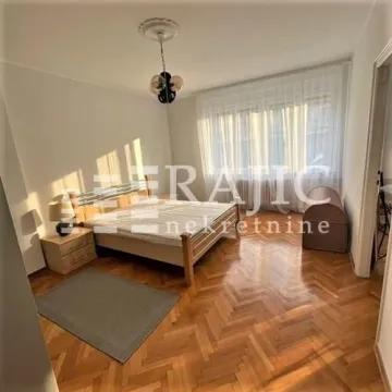 Furnished bedroom with a double bed, wooden parquet flooring, and a large window. - image 5