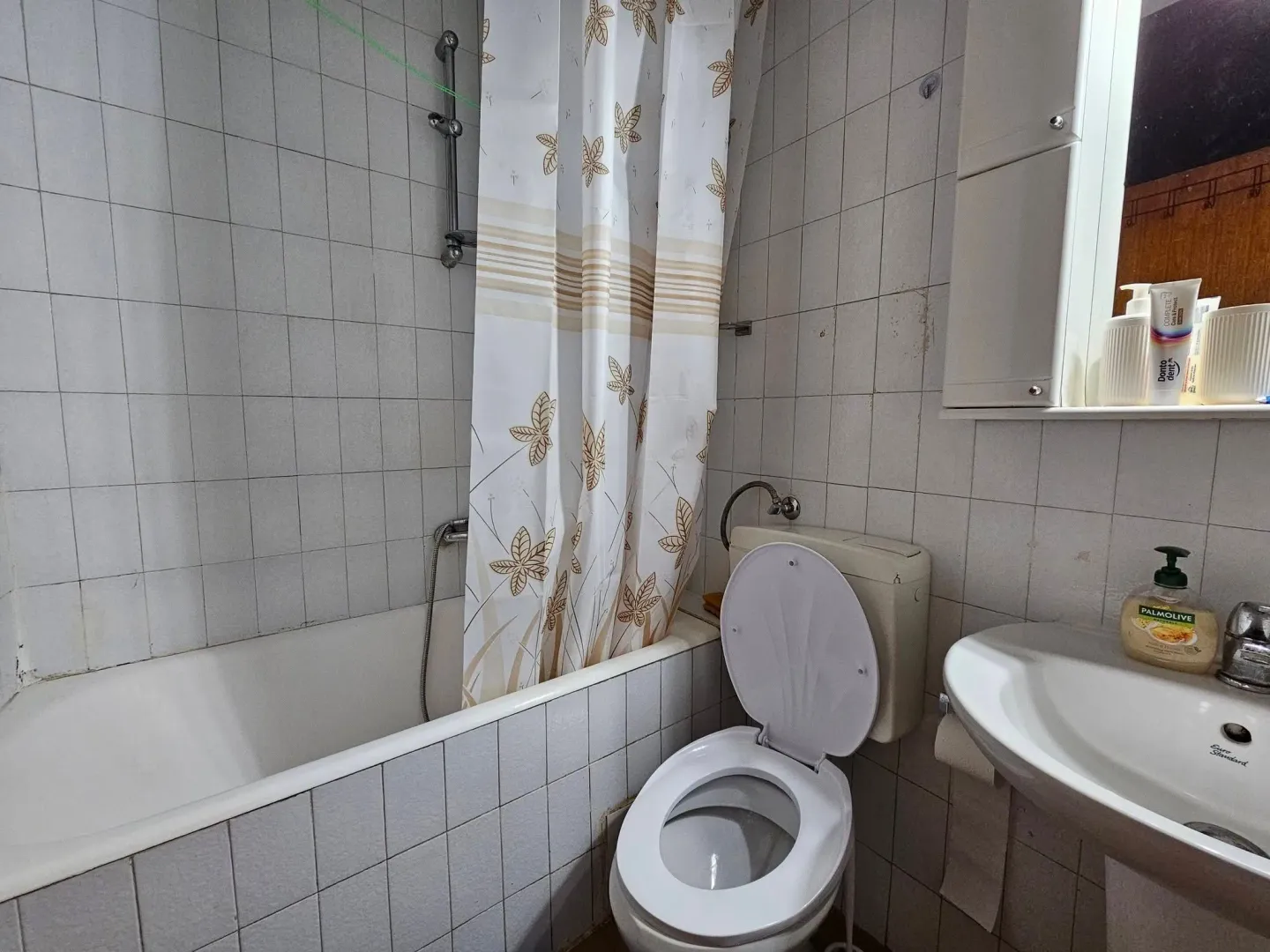 Smaller bathroom with a bathtub, toilet, and sink.