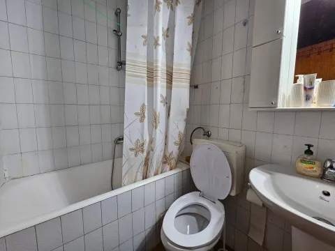 Smaller bathroom with a bathtub, toilet, and sink. - image 10
