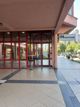 Entrance to a commercial property with red-framed glass doors and windows. - image 4