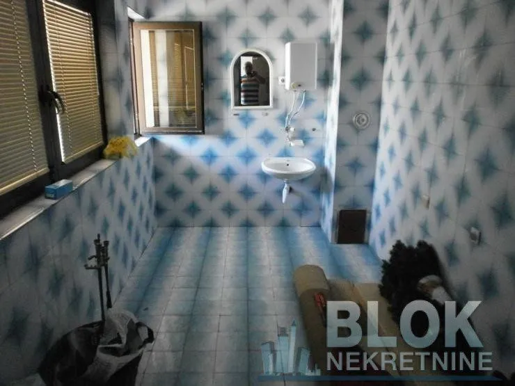 Tiled bathroom with a washbasin and a window.