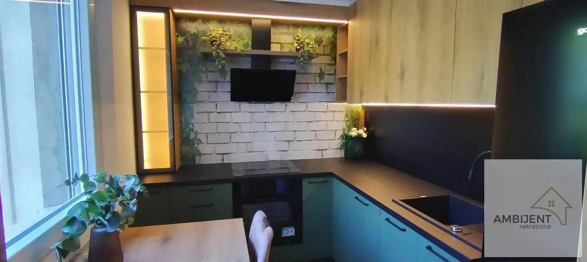 Modern kitchen with green cabinets and integrated lighting.