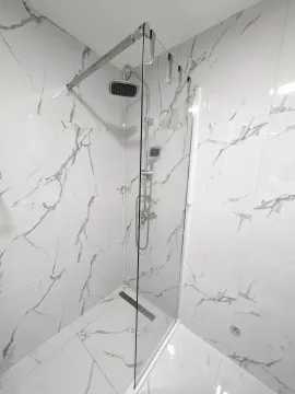 Modernly equipped bathroom with a walk-in shower lined with marble tiles. - image 8