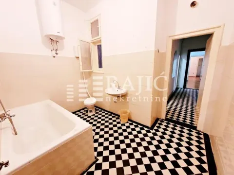 Spacious bathroom with a bathtub and black and white ceramic floor tiles. - image 9