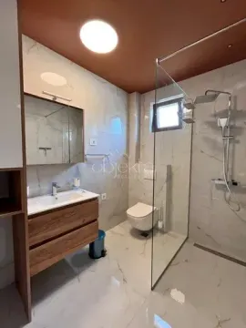 Moderno opremljeno kupatilo sa tuš kabinom, umivaonikom i toaletom. - image 10