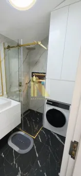 Moderno opremljeno kupatilo sa tuš kabinom, umivaonikom i ugrađenom veš mašinom. - image 22