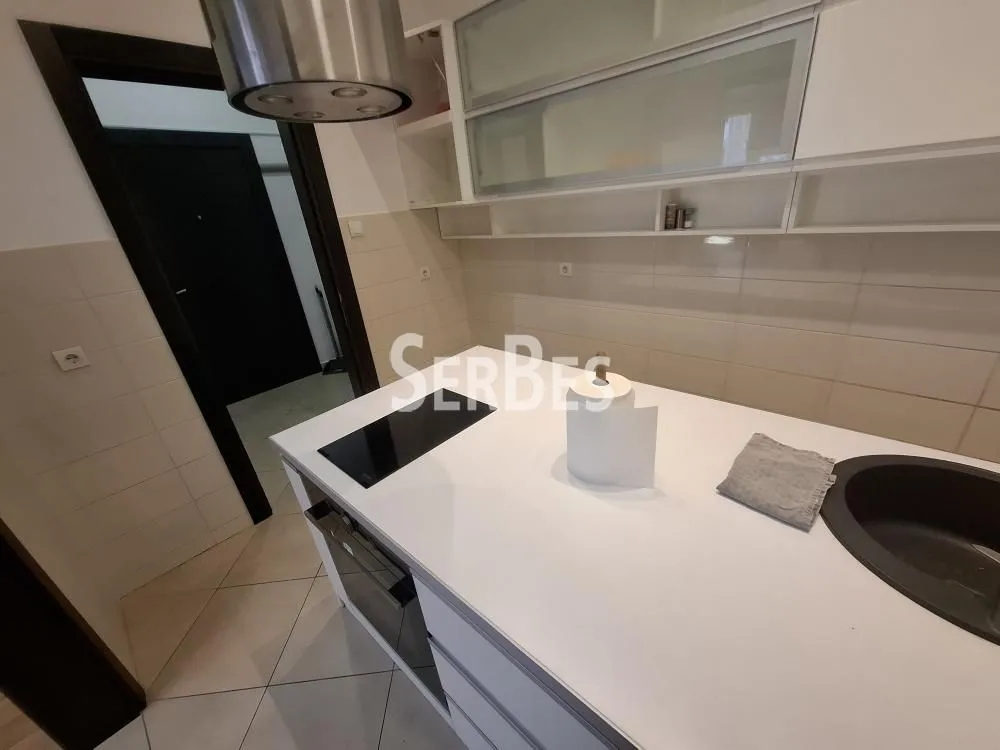 View of the kitchen with white cabinets and a kitchen island.