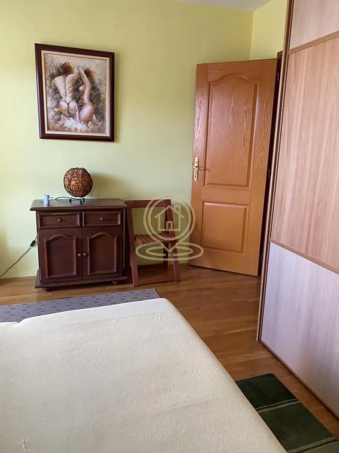 Small bedroom with a bed, wooden chest of drawers, and a wardrobe.