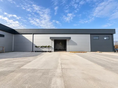 View of the exterior of an industrial building with a concrete platform and entrance door. - image 8