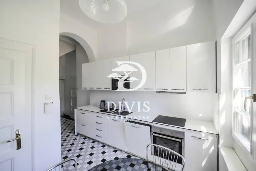 White kitchen with cabinetry and built-in appliances in an apartment.