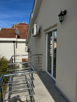 Balcony with a metal railing and access to the building. - image 12