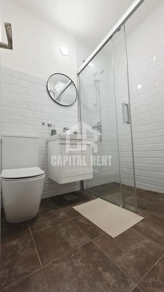 Modernly equipped bathroom with a walk-in shower and white sanitaryware.