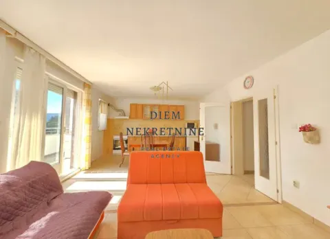 Living room with a sofa set and dining area in the background. - image 13