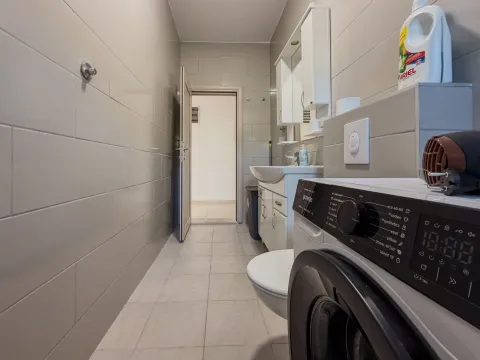 Kupatilo opremljeno sanitarijama, umivaonikom i veš mašinom. - image 13
