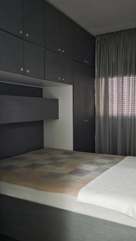 Furnished bedroom with built-in wardrobes and a window.