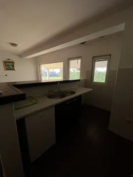 Jednostavna kuhinja sa šankom, sudoperom i pogledom na dvorište. - image 12