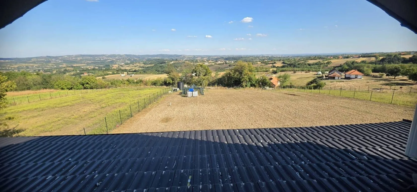 Pogled na dvorište i okolni pejzaž sa terase kuće.