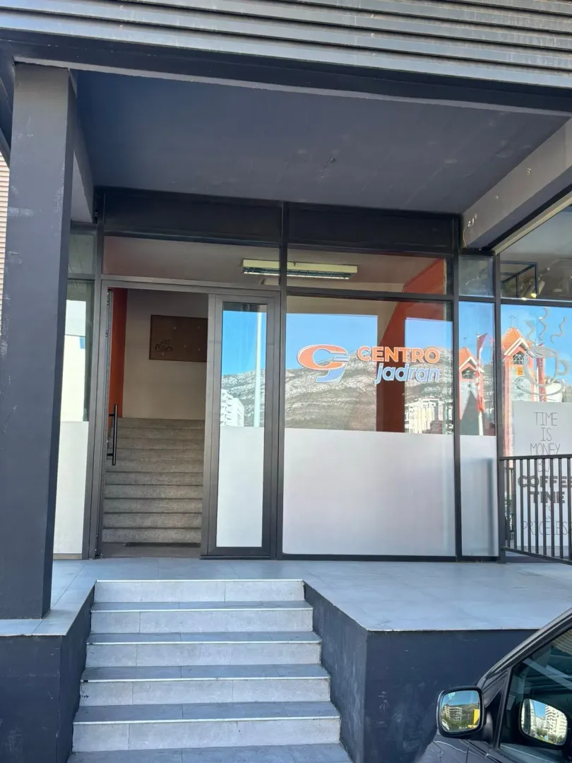 Commercial space entrance with stairs and a glass facade.