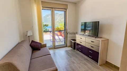 Manji dnevni boravak sa trosjedom, komodom sa TV-om i izlazom na terasu sa pogledom na more. - image 12