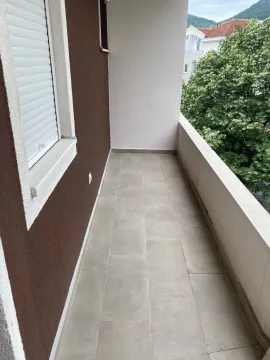 Pogled na prostrani popločani balkon sa ogradom. - image 9