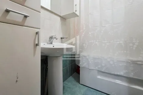Small bathroom with a sink and a bathtub with a curtain. - image 7