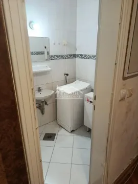 View of the bathroom with a washbasin and washing machine through an open door. - image 13