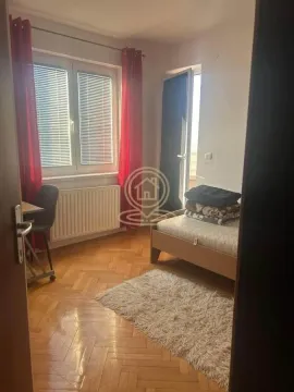 Manja spavaća soba sa krevetom, radnim stolom i prozorom sa crvenim zavesama. - image 6