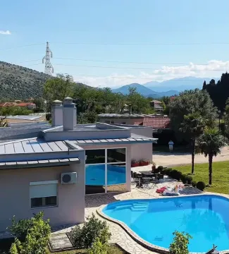 View of the house exterior with a swimming pool and landscaped yard. - image 3