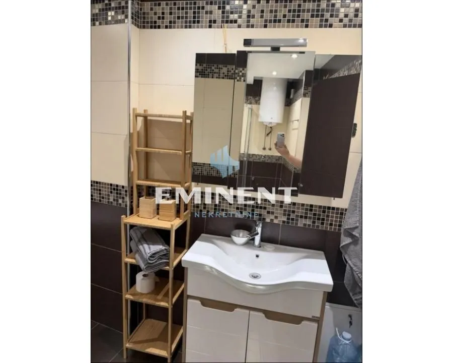 Bathroom with a sink, mirror, and wooden shelving unit.