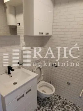 Modernly equipped bathroom with white tiles and sanitary ware. - image 11